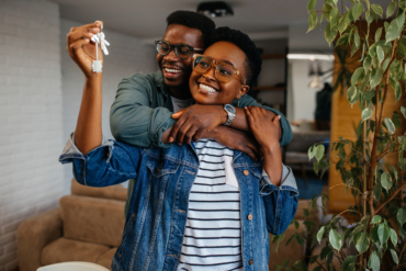 First home buyer in Ghana — couple celebrating with keys to their new starter home